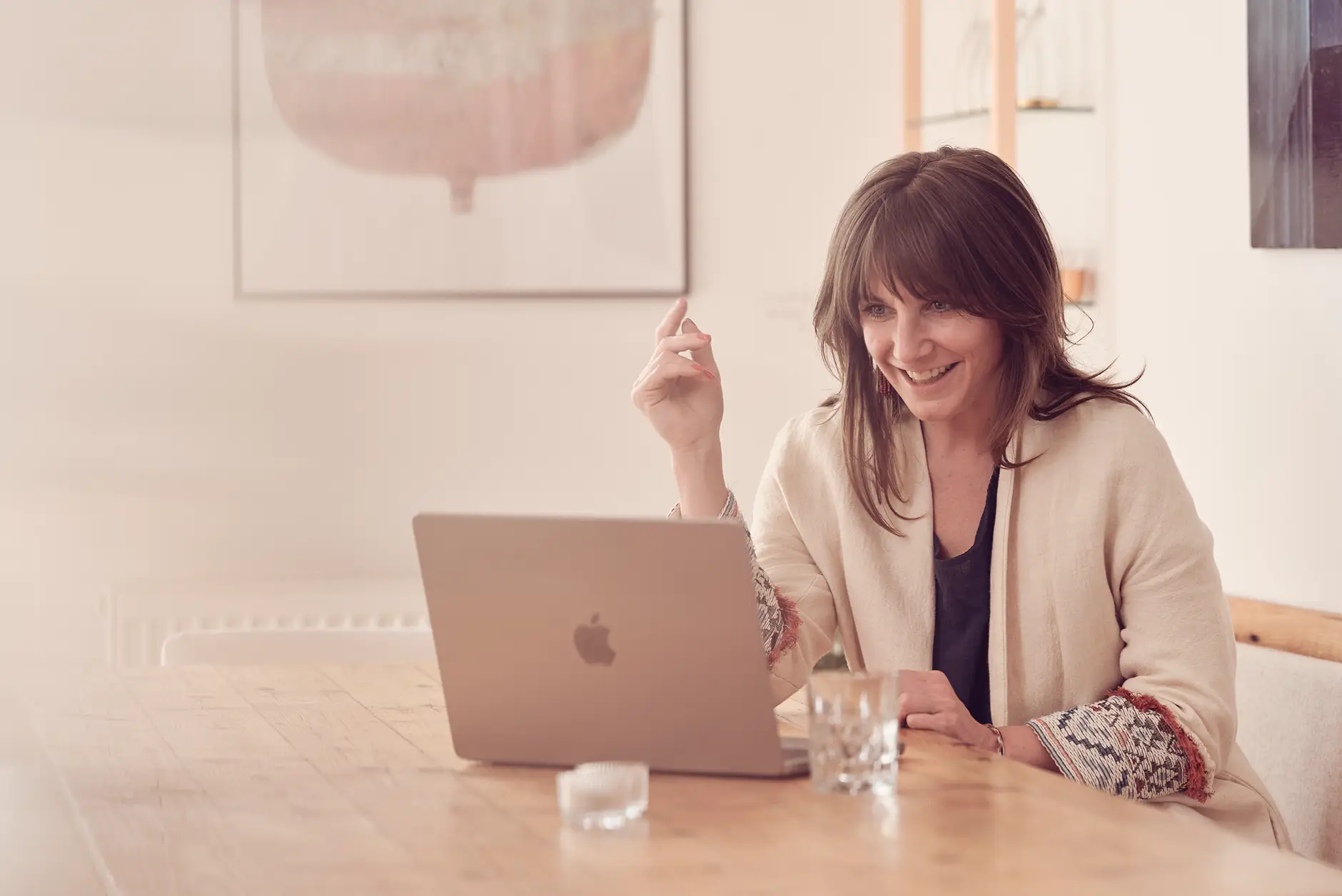 Janna Raphaela Odesser sitzt lächelnd vor einem Laptop in einem hellen Raum und führt ein Online-Gespräch